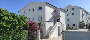ein paar weiße Gebäude mit einem Zaun in der Unterkunft Villa Dusper in Trogir