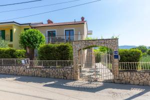 a house with a gate and a stone wall at Apartments "Alen" in Nedeščina