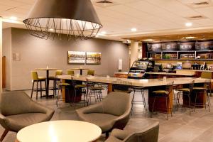 Un restaurante con mesas y sillas y un bar. en Courtyard by Marriott Yonkers Westchester County, en Yonkers