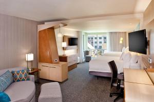 a large hotel room with a bed and a couch at Courtyard by Marriott Yonkers Westchester County in Yonkers