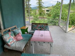 a porch with a table and a couch and a table at hotel pillows in Martvili