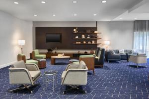 a lobby with chairs and a flat screen tv at Courtyard by Marriott Atlanta NE/Duluth Sugarloaf in Duluth