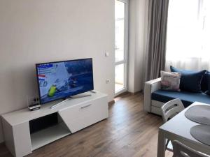 ein Wohnzimmer mit einem Flachbild-TV auf einem weißen Schrank in der Unterkunft HOT Main Square Newly Built Modern Apartment in Burgas City