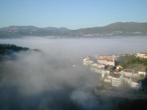 a view of a city in the fog with mountains at Apartamento Montes e Vales no Centro in Vila Real