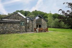 a stone house with a table and chairs at Panoramic Views & Spacious Living by LetMeStay in Grasmere