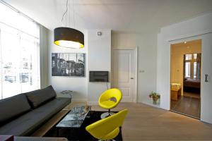 a living room with a couch and a yellow chair at Suite aan de A in Groningen