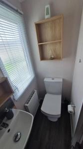 a bathroom with a white toilet and a sink at STYLISH MODERN CONTEMPORARY PET FREE HOLIDAY HOME ON AWARD WINNING SHOREFIELD COUNTRY PARK Edge New Forest ENTERTAINMENT AND LEISURE PASSES INCLUDED in Milford on Sea +11 photos