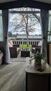 a living room with a couch and a table at STYLISH MODERN CONTEMPORARY PET FREE HOLIDAY HOME ON AWARD WINNING SHOREFIELD COUNTRY PARK Edge New Forest ENTERTAINMENT AND LEISURE PASSES INCLUDED in Milford on Sea