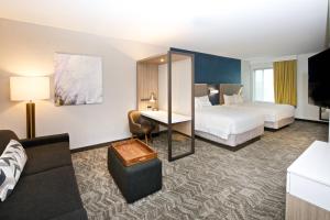 イサクアにあるSpringHill Suites by Marriott Seattle Issaquahのベッド2台とデスクが備わるホテルルームです。