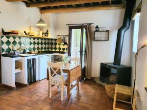 a kitchen with a table and a stove at La Placeta Guesthouse in Pórtugos
