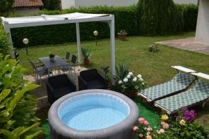 a backyard with a hot tub and chairs and an umbrella at Villa Luisa Design in Colle di Val d'Elsa