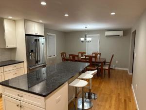a kitchen and dining room with a counter and a table at Boston Single Family House - 19' Train to Back Bay in Boston
