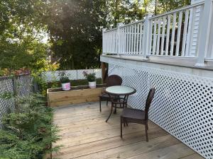 a patio with two chairs and a table on a deck at Boston Single Family House - 19' Train to Back Bay in Boston
