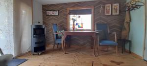 a dining room with a table and chairs and a window at Tuinhuis In je Element in Hoogeveen +1 photo