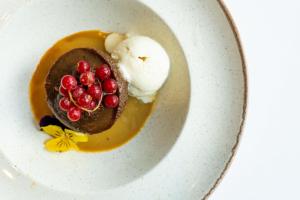 a plate with a chocolate dessert with ice cream and cranberries at Aloft London Excel in London