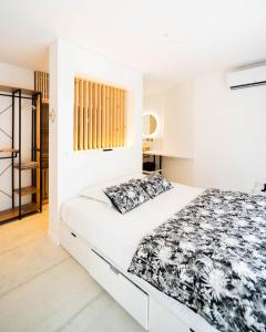 a white bedroom with a large bed with black and white sheets at Bordeaux cosy home in Bordeaux