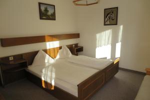 Schlafzimmer mit einem großen Bett mit einem Kopfteil aus Holz in der Unterkunft Haus Enzian in St. Johann im Pongau