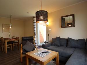 a living room with a couch and a table at Bungalow in Dornumersiel in Dornumersiel