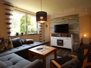 a living room with a couch and a tv at Bungalow in Dornumersiel in Dornumersiel