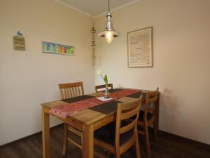 a dining room table with chairs and a table and a lamp at Bungalow in Dornumersiel in Dornumersiel +32 photos