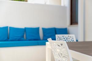 a white chair sitting next to a table with a blue couch at Casa Vacanze Elvè in Paestum