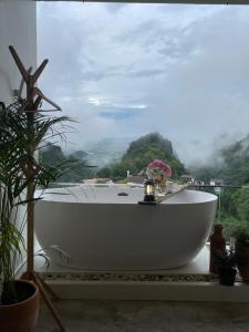 a bath tub sitting on top of a balcony with a view at Layo Homestay in Ban Pha Mi