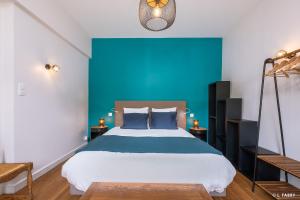 a bedroom with a large bed with a blue wall at Maison SAUTREAU Bout du Lac in Doussard