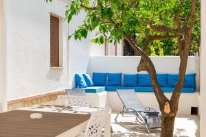 un patio con tavolo, sedie e un divano blu di Casa Vacanze Elvè a Paestum
