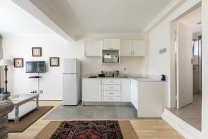 una cucina con armadietti bianchi e frigorifero di Emmarentia Guest House a Johannesburg