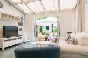 Una sala de estar con un sofá y un televisor. en Villa Penelope, en Granelli