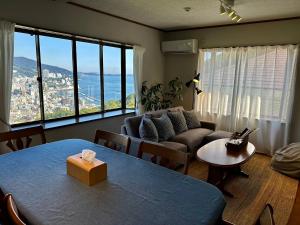 un soggiorno con un divano e un tavolo di 熱海天海ヴィラ/ Atami Tenkai Villa ad Atami