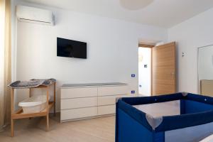 un soggiorno con sedia blu e TV di Casa Vacanze Elvè a Paestum