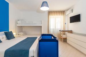 una camera con letto blu e bianco e TV di Casa Vacanze Elvè a Paestum