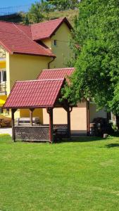a pavilion with a red roof in front of a house at Green Villas Tjentiste in Tjentište