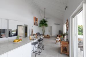 a kitchen and living room with white cabinets and a counter at Villa Moai in Saint Martin