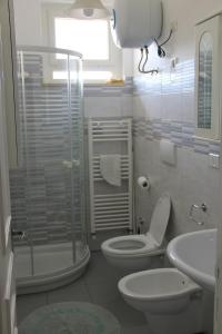 a bathroom with a toilet and a shower and a sink at La Casetta di Gabri in San Vito Chietino