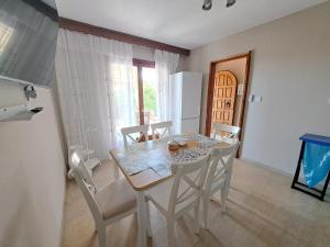 a dining room with a table and chairs and a refrigerator at CASA Di TRE MARE in Nea Kallikrateia +38 photos
