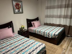 a bedroom with two beds and a window at La Vista Bay North Coast Halafawy's Full Sea View لا فيستا باي الساحل الشمالي بيت الحلفاوي in Dawwār Ḩājj as Sayyid Rizq