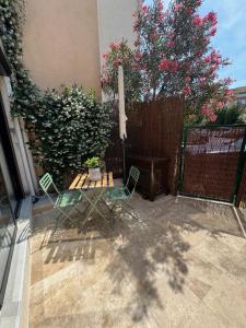 a patio with a table and chairs and a fence at Chez Timmaflo in Fréjus