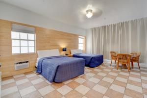 een hotelkamer met 2 bedden en een tafel en stoelen bij James Hotel in Miami Beach