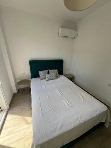 a bedroom with a large white bed with two pillows at Perla 2 Paralia Ofriniou in Ofrínion