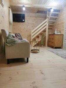 a living room with a couch and a staircase at Letniczówka Guciów-Pokochaj Roztocze in Guciów
