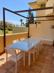 einen weißen Esstisch und Stühle auf dem Balkon in der Unterkunft Victor Villa Romana in Roquetas de Mar