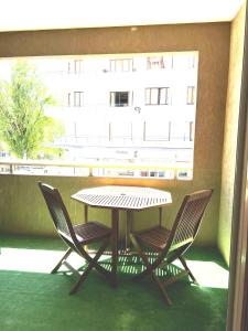 uma mesa e cadeiras numa varanda com uma janela em Annecy centre-ville avec garage et loggia em Annecy