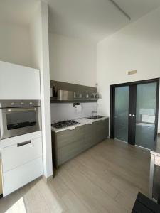 a kitchen with white cabinets and a stove top oven at Artemide Resort Spa - Private Villa in Lido Di Fondi