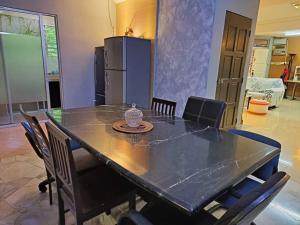 a black table with chairs and a refrigerator at Hill Top 2StoreyHouse BktAntarabangsa,Free Unlimited Parking in Ampang