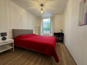 sypialnia z czerwonym łóżkiem i oknem w obiekcie Cosy Poullan, 2-bedroom apartment, 200 m from the beach w Nicei