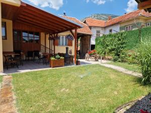 a backyard with a patio with a grass yard at Konak -Guest house -Ramonda Serbika in Niš