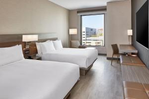 um quarto de hotel com duas camas e uma grande janela em AC Hotel by Marriott Sacramento em Sacramento