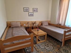 a small room with two beds and a table at Konak -Guest house -Ramonda Serbika in Niš